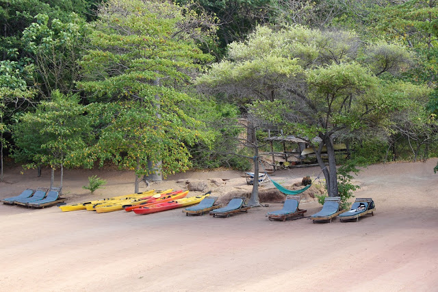 Sun loungers and kayaks on the main beach at Mumbo Island
